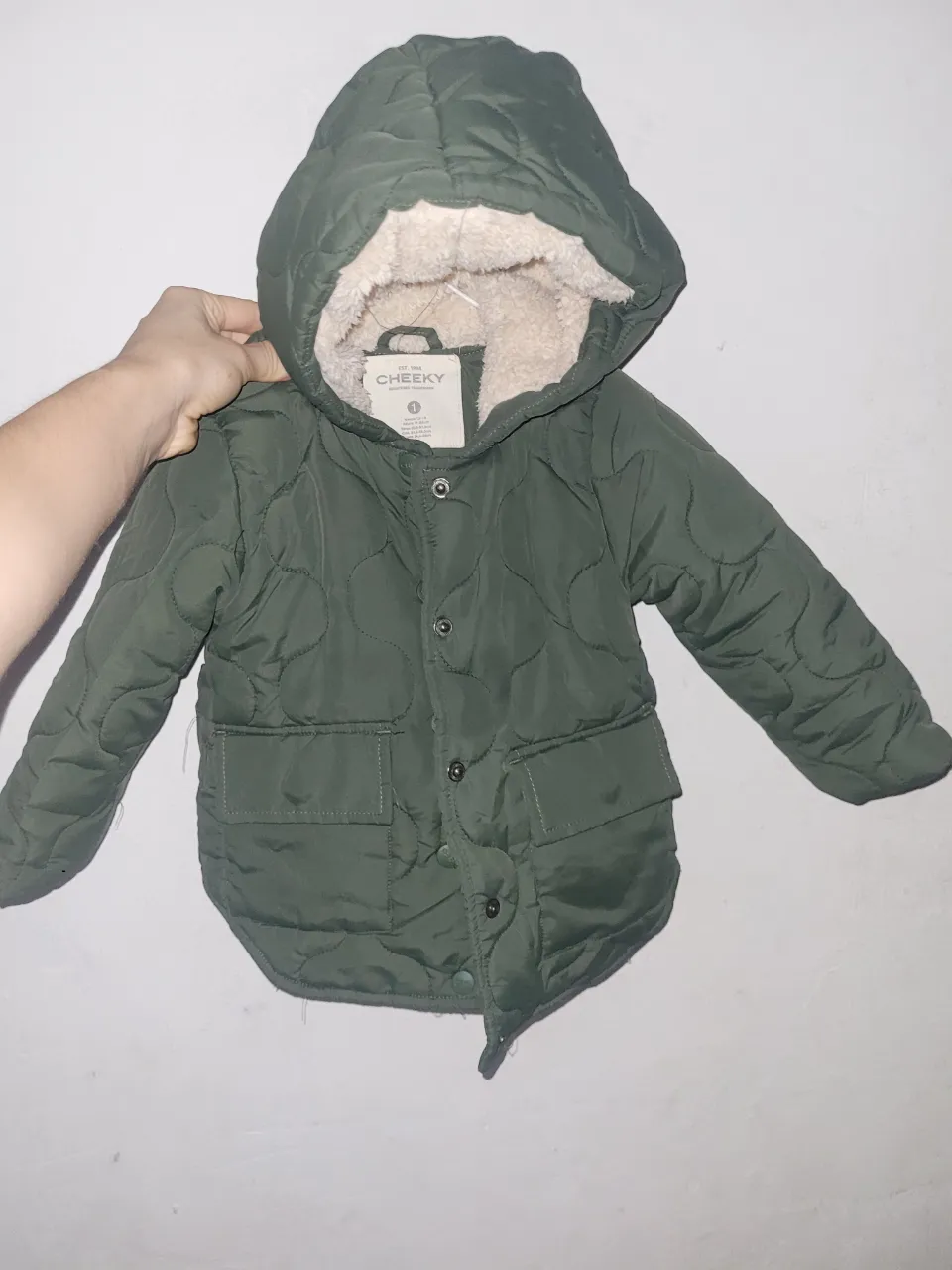 Campera acolchada verde con interior de corderito. Posee capucha, bolsillos delanteros y se abrocha con botones.
para 2 / 3 años niño /a
