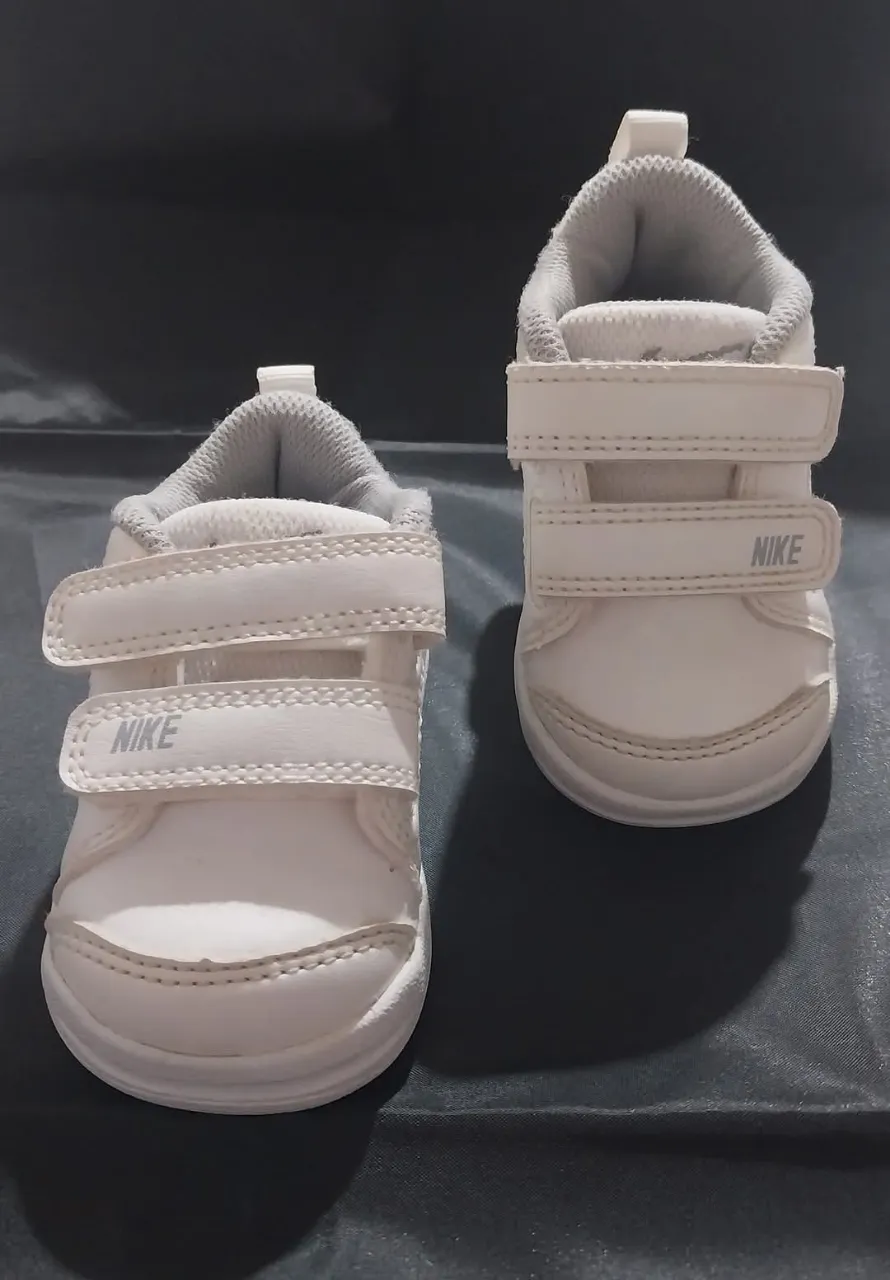 Zapatillas de bebé Nike blancas con abrojo.