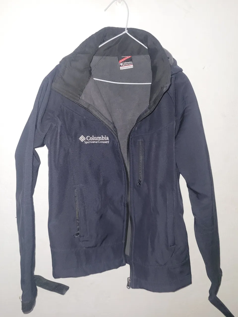 Campera azul marino Columbia Sportswear Company con cierre completo y capucha. Posee bolsillos frontales con cierre y bolsillos internos de red.