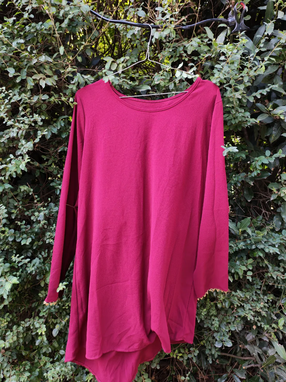 Remera manga larga/vestido en color fucsia, con detalles de puntilla dorada en los puños. Ideal para un look casual y cómodo.