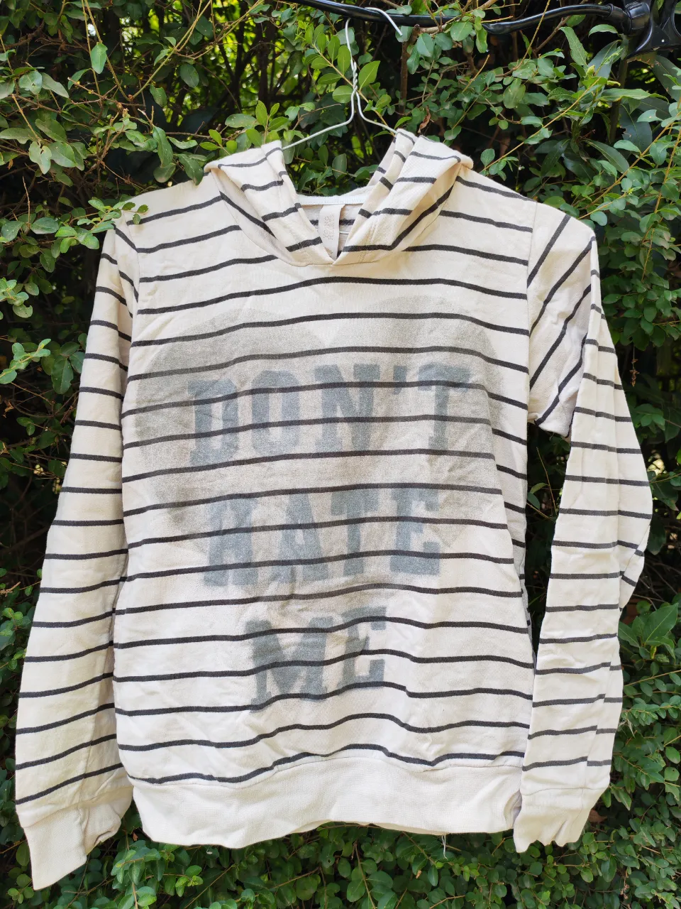 Buzo 47 Street con capucha a rayas blancas y negras, con estampa "DON'T HATE" en el frente. Ideal para un look casual y relajado.