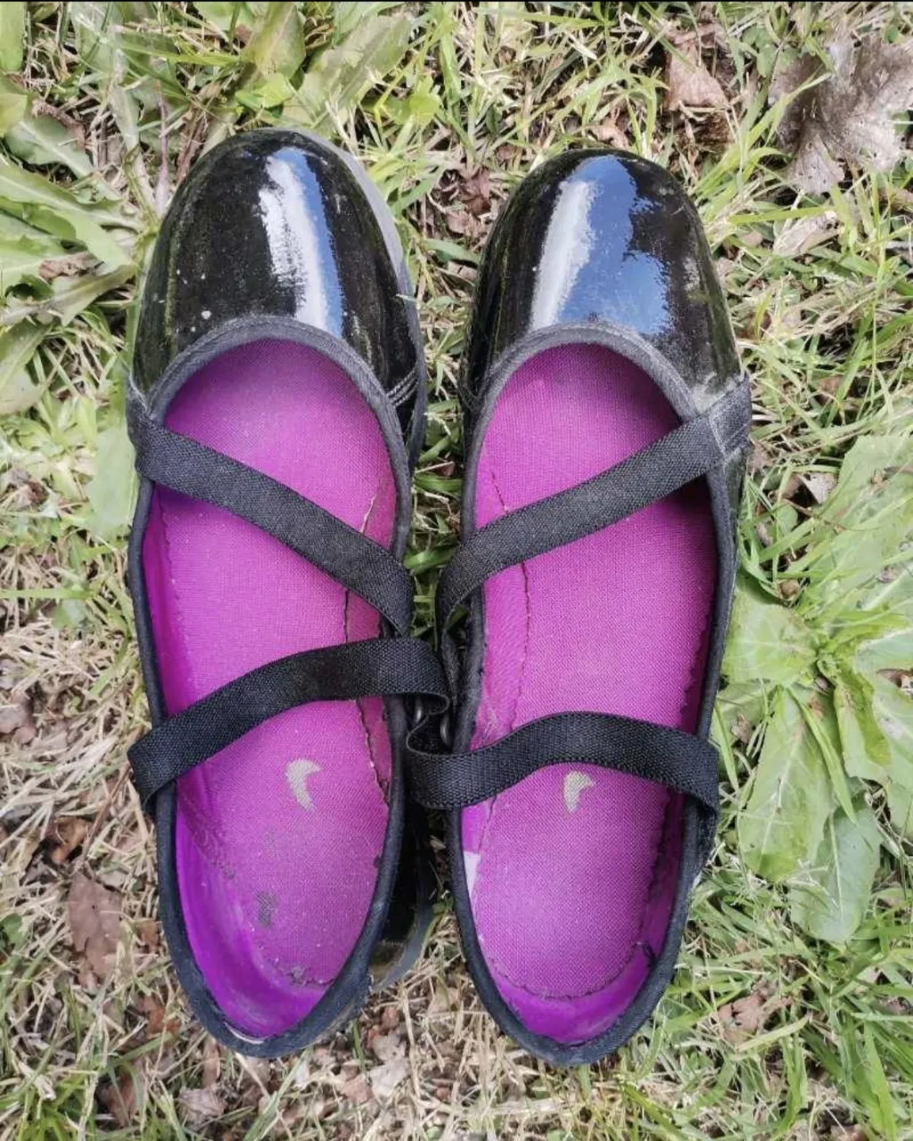 Sandalias deportivas negras marca Nike charoladas con detalles en fucsia y tiras cruzadas.