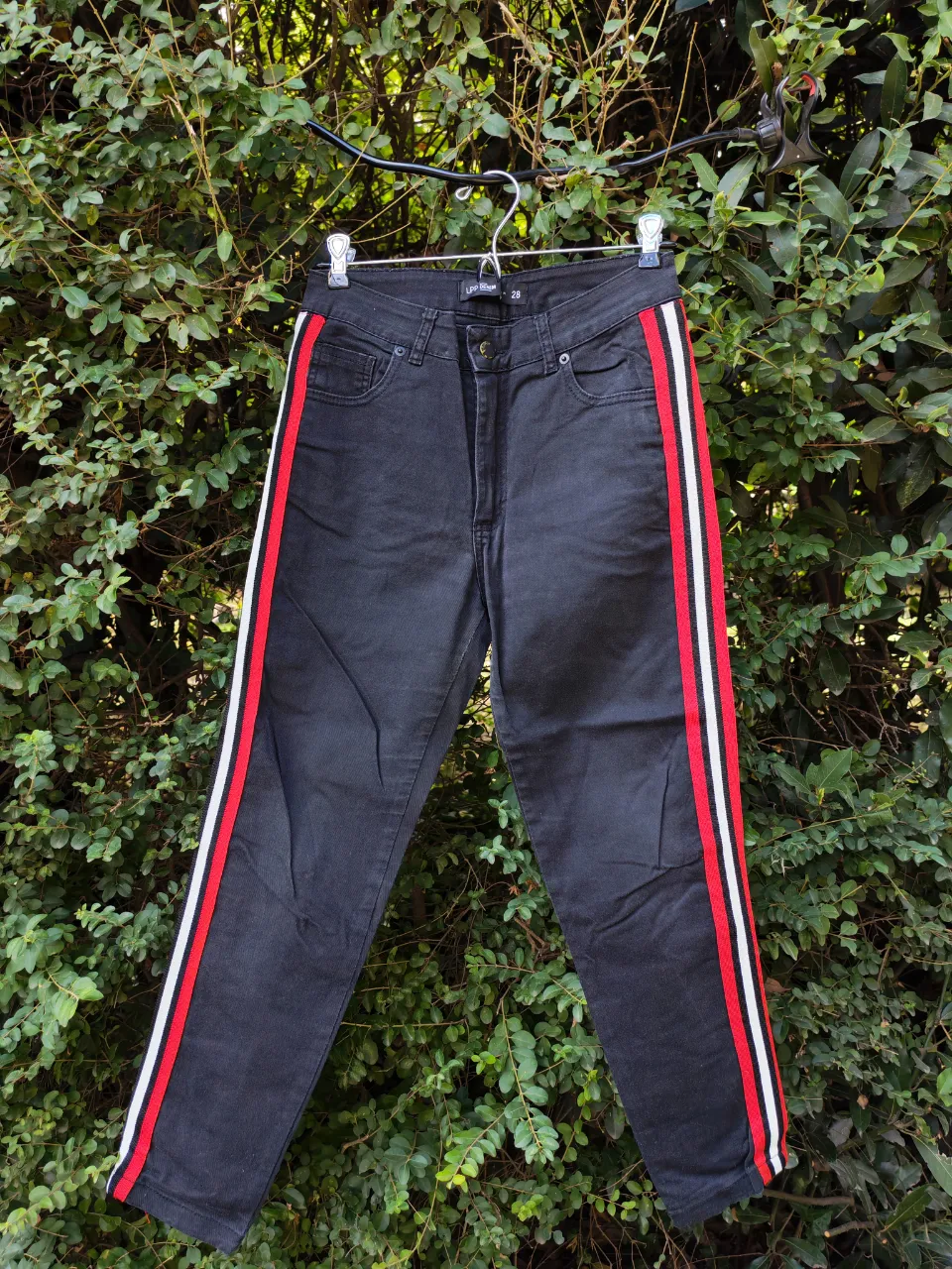 Jean de tiro alto con detalles de tiras laterales en rojo y blanco. Un clásico renovado para un look moderno y canchero.