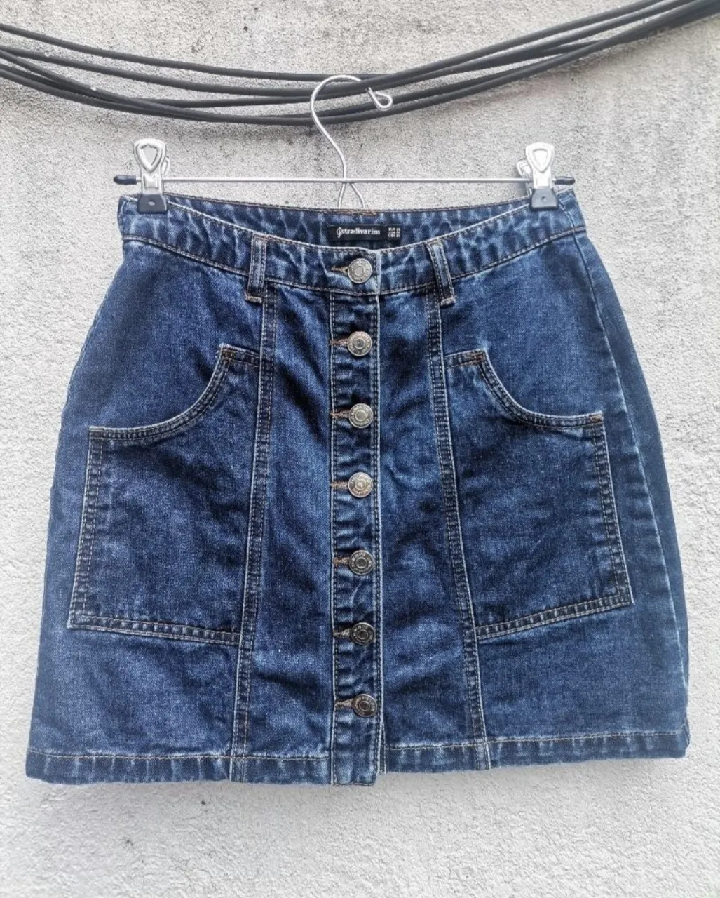 Pollera de jean azul con botones al frente y bolsillos.
Medidas: cintura 32cm, cadera 46cm, largo total 38cm