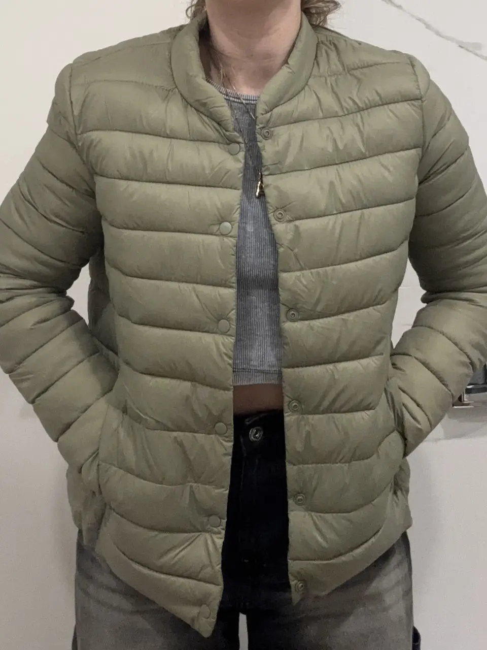 Campera de pluma acolchada verde oliva de la marca H&M, ideal para el invierno. Talle 10 US. Cierre con botones y cuello redondo.