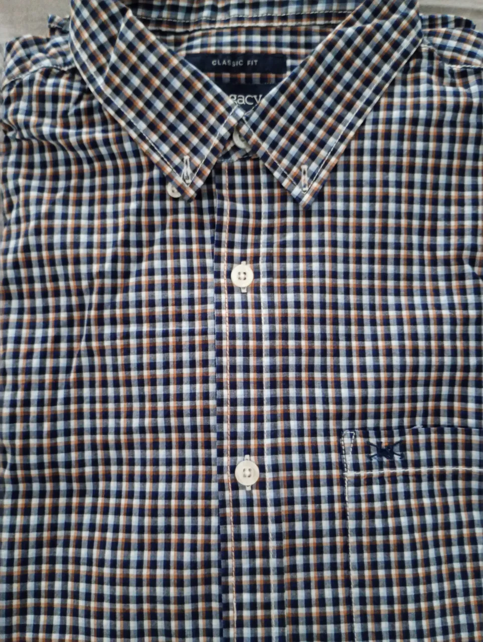 Camisa a cuadros de manga larga con botones al frente y bolsillo en el pecho.