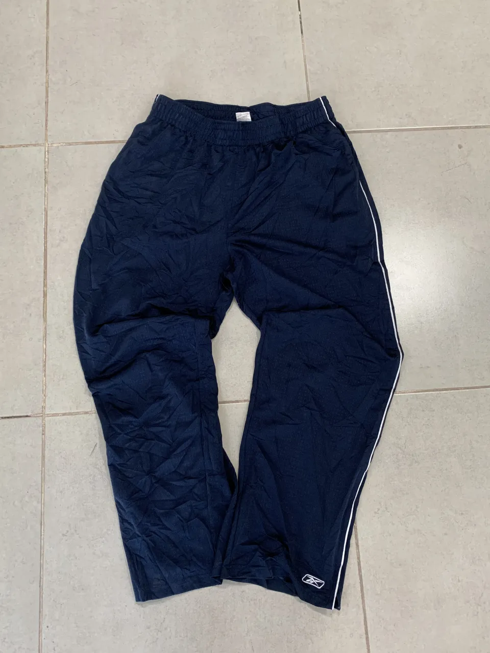 Pantalon deportivo azul marino con detalles blancos. Ideal para entrenar o para un look casual.