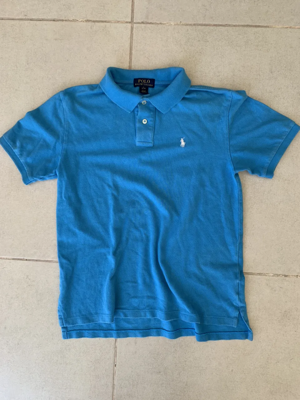 Remera polo azul de manga corta, con el clásico logo del caballito bordado en blanco. Ideal para un look casual y canchero.