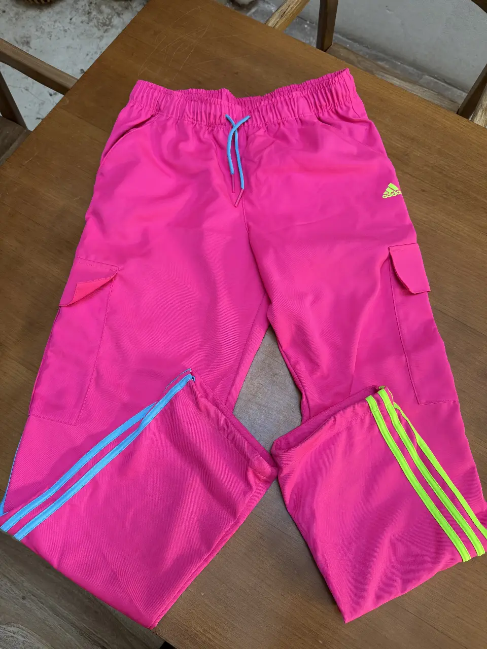 Pantalón deportivo Adidas rosa chicle con detalles en azul y verde lima. Talle XL. Ideal para actividades deportivas o un look casual.