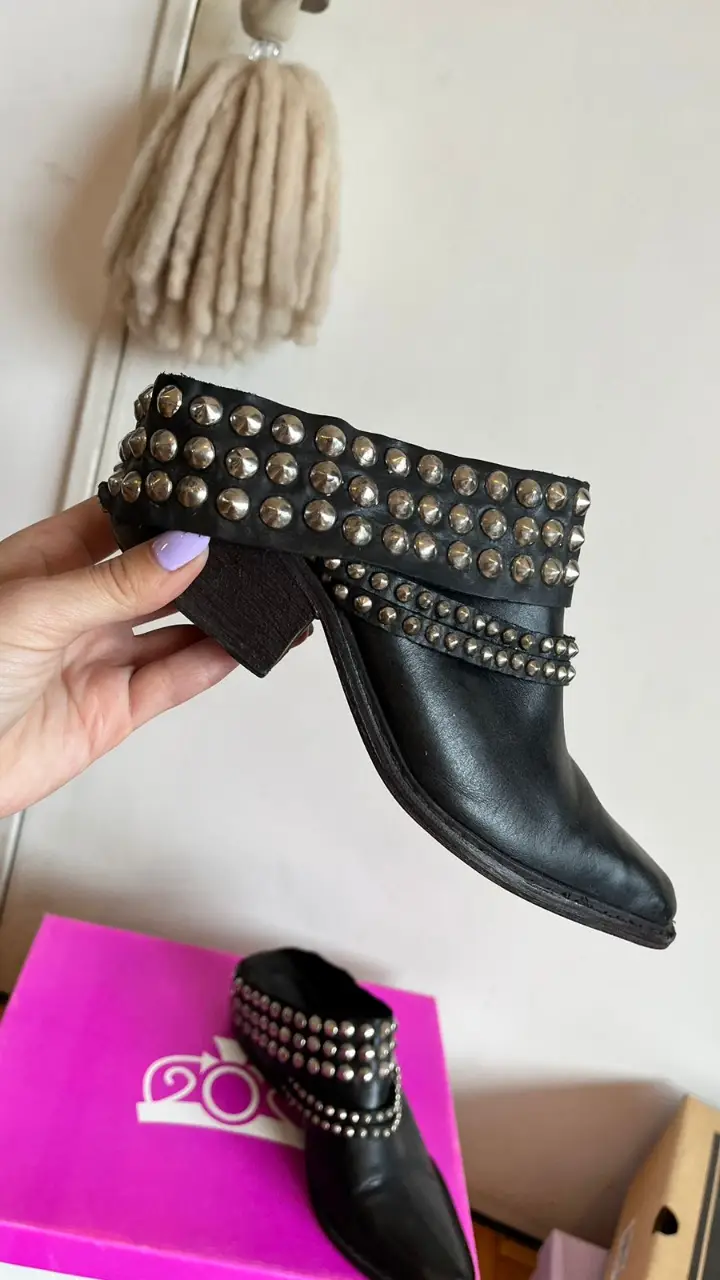Botines negros de cuero con detalles de tachas plateadas. Estilo rocker, ideales para darle un toque audaz a cualquier look. Perfectos para salir o para un estilo más urbano.