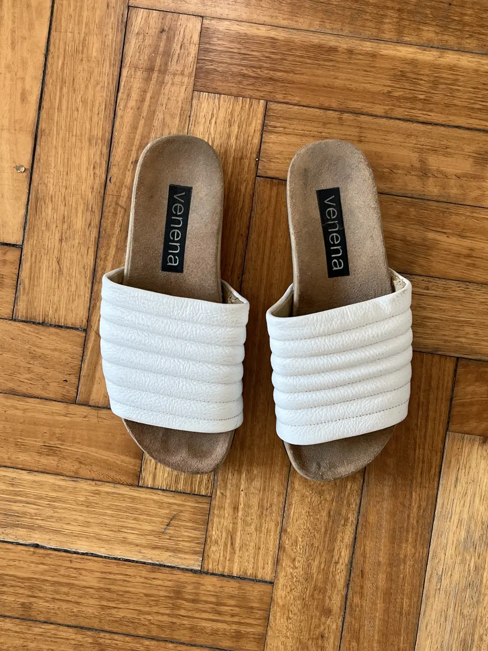 Sandalias Venena blancas con diseño acolchado. Ideales para un look casual y cómodo en verano.