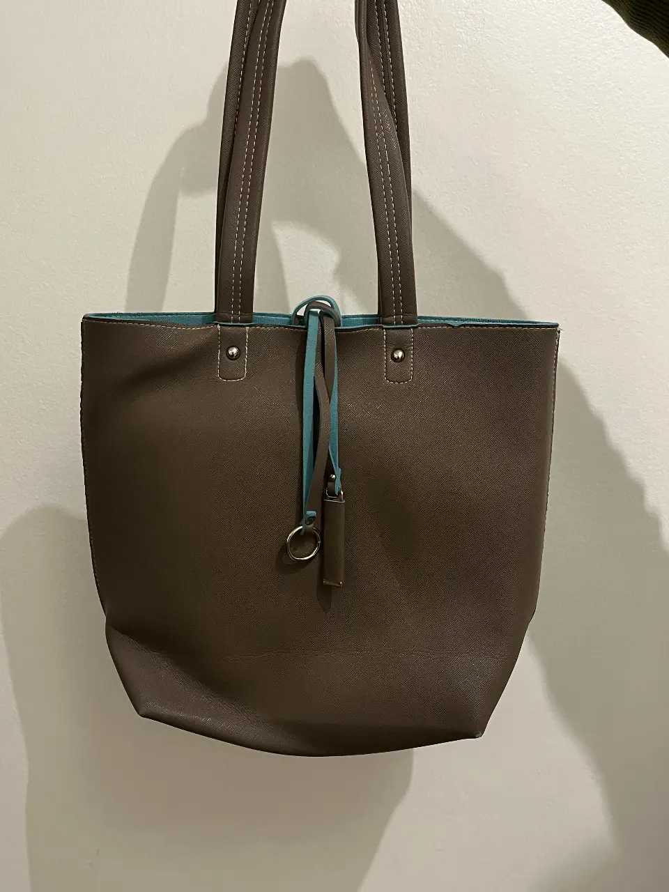 Bolso tote de cuero sintético marrón con interior celeste. Ideal para llevar todo lo que necesitas con estilo y comodidad.