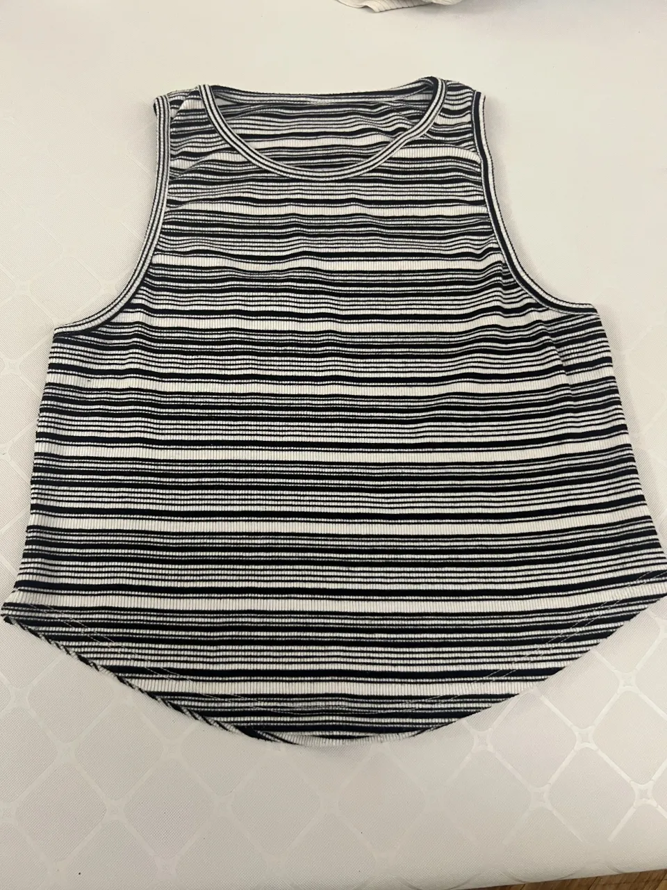 Musculosa a rayas blancas y negras. Con corte redondo en la parte de abajo 