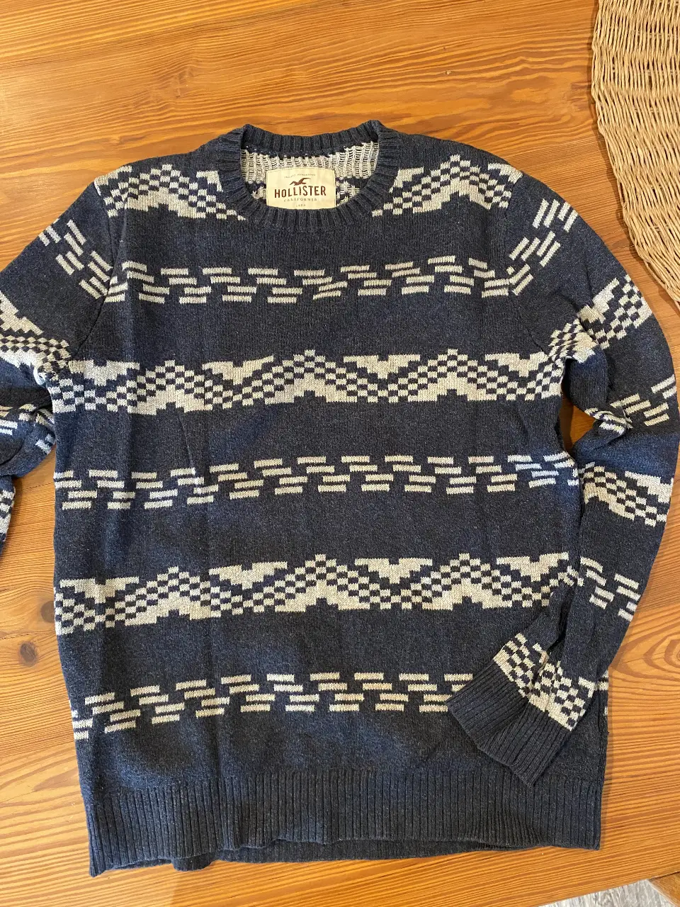 Sweater Hollister azul marino con diseño geométrico en gris. Talle M, ideal para un look casual y abrigado.