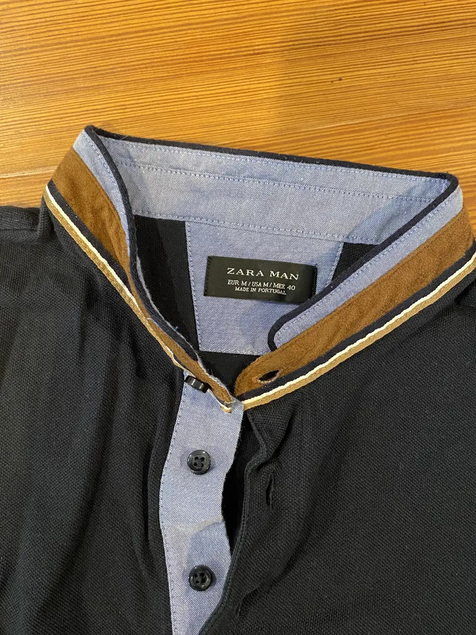 Remera polo de hombre, color negro con detalles en el cuello y mangas en blanco y marrón. Marca Zara Man, talle M.