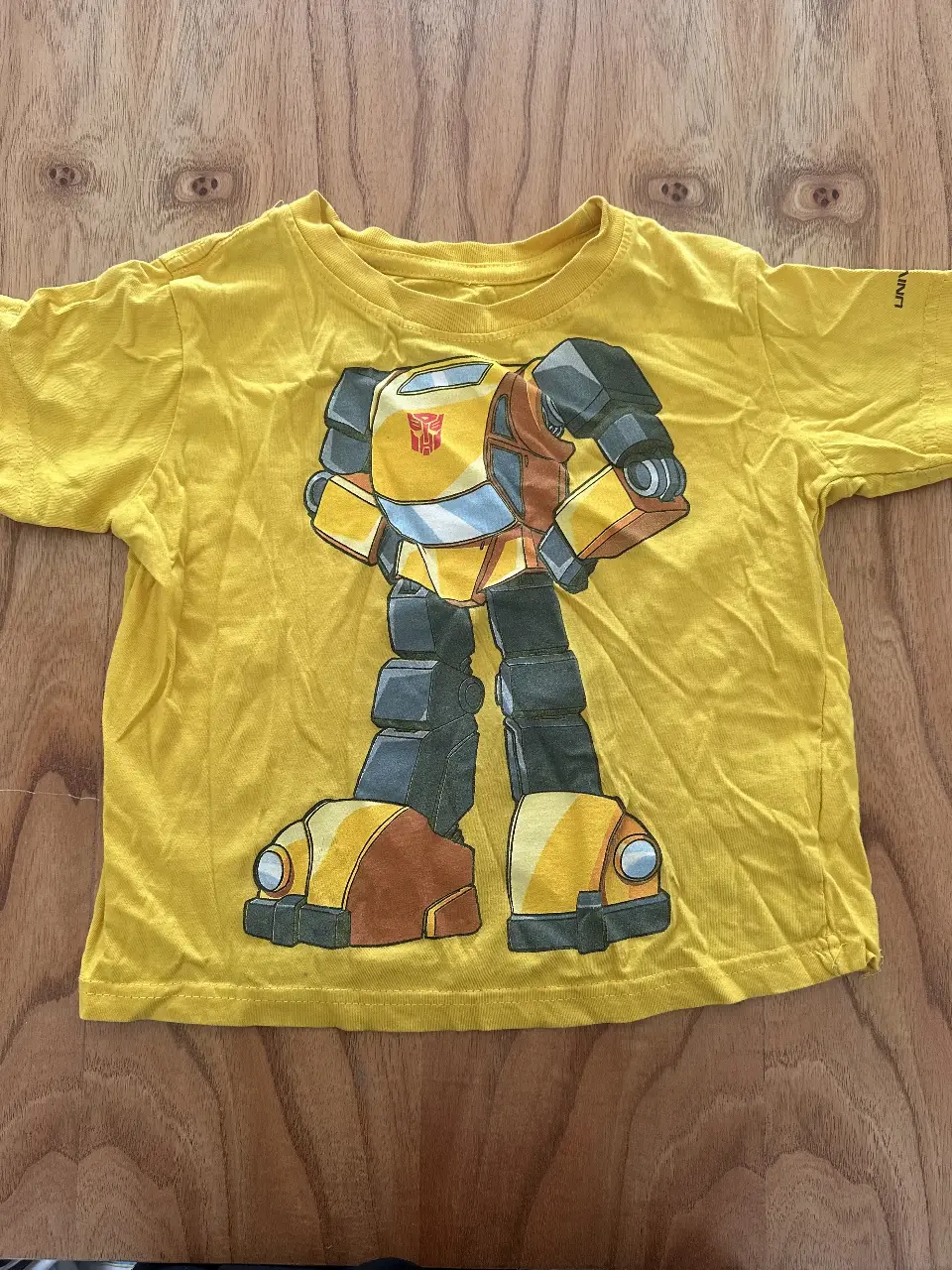 Remera amarilla de manga corta para niño, con estampado de Bumblebee de Transformers. Ideal para un look casual y divertido.