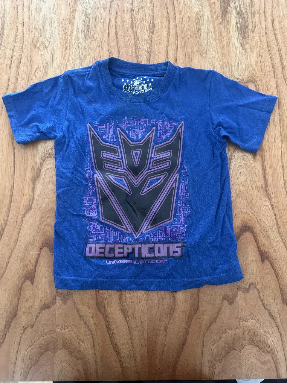 Remera azul de manga corta para niño, con estampado del logo de los Decepticons de la película Transformers. Ideal para fans de la saga.