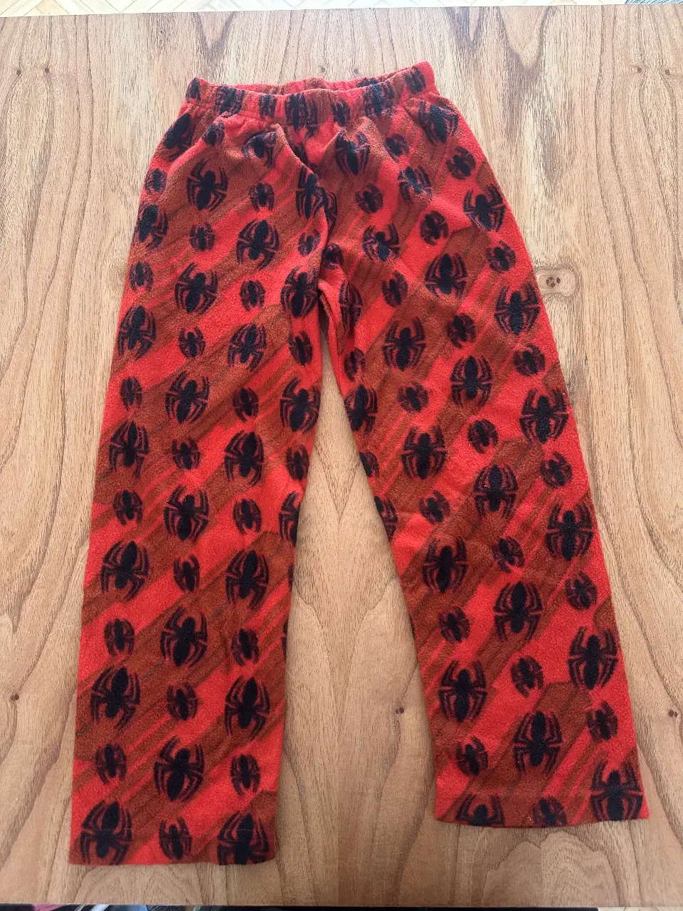 Pantalón de pijama para nene con estampado de arañas en rojo y negro. Ideal para estar cómodo en casa.