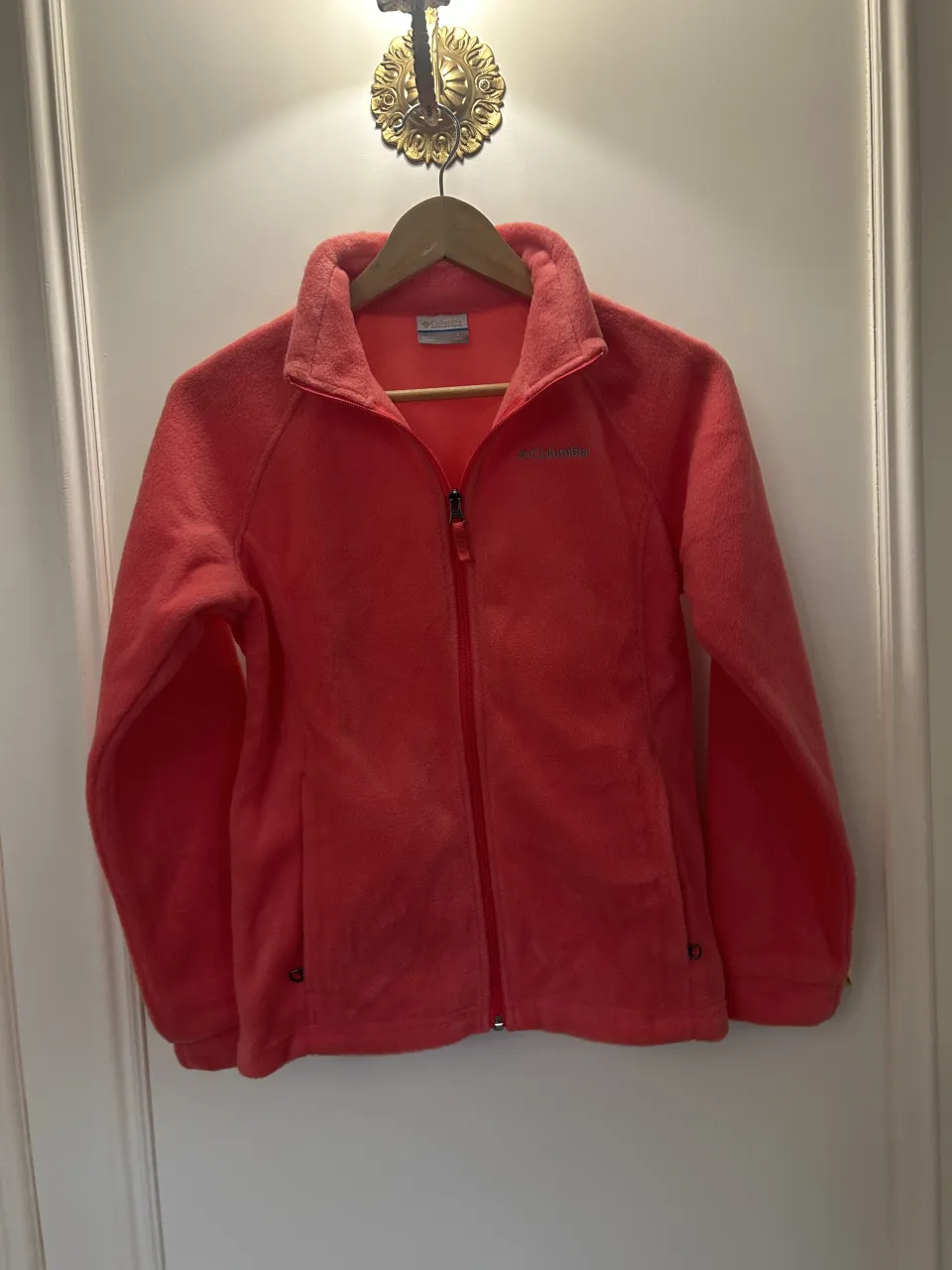 Campera de polar con cierre completo y cuello alto. Posee dos bolsillos frontales con cierre. Logo de la marca bordado en el frente.