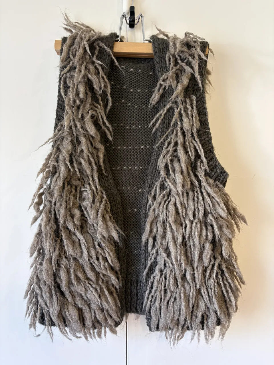 Chaleco tejido de lana con apliques de pelo largo y deshilachado en el frente y la espalda. Diseño sin mangas y sin botones. medidas : 30cm hombros, 40cm axila axila, 54cm largo