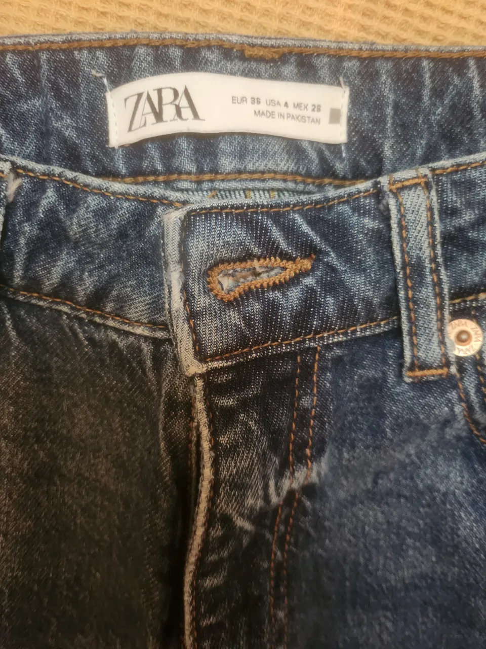 Jeans de algodón azul con detalles de desgaste.