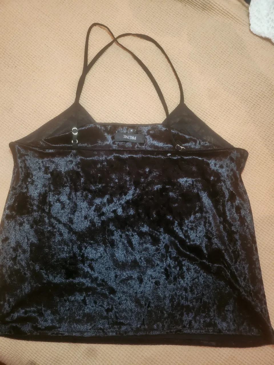 Top de terciopelo negro con tiras finas cruzadas en la espalda.