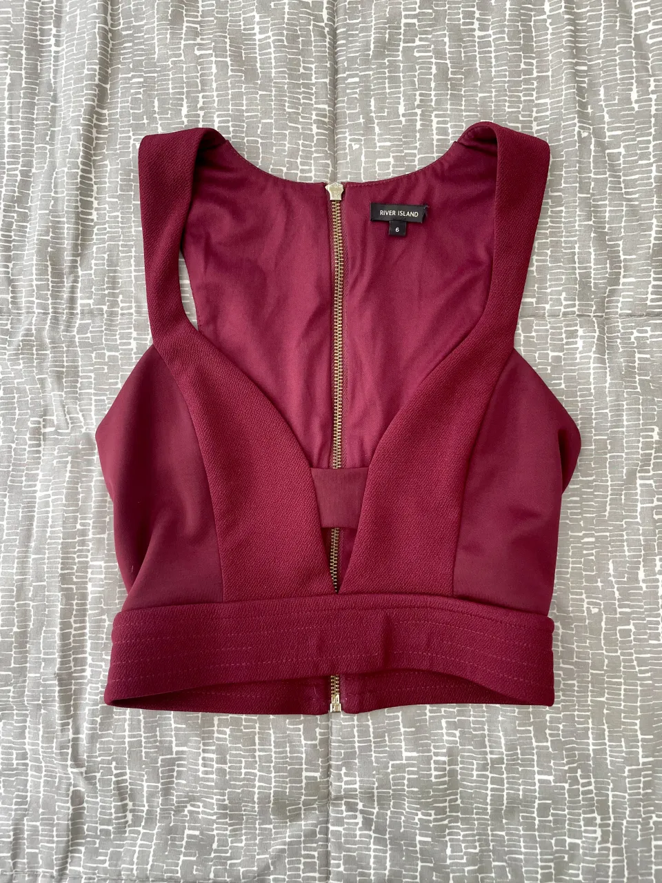 Top crop de fiesta en color bordó con diseño escotado y cierra en la espalda con detalle de moñito. 