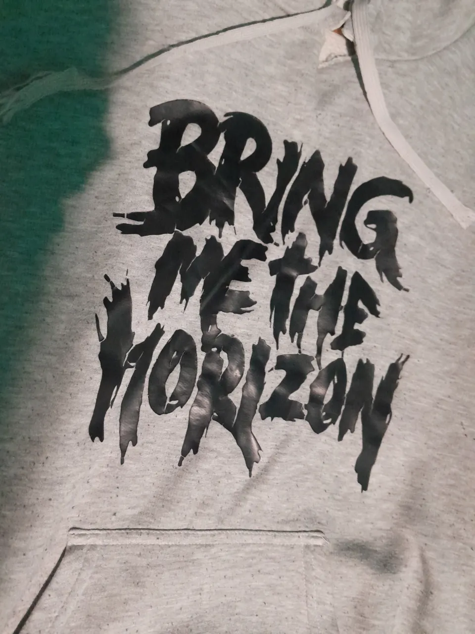 Buzo gris con estampa "BRING ME THE HORIZON" en negro. Posee bolsillo canguro y cordones blancos en la capucha
...
Largo 71cm
Ancho 60cm 
Manga 62cm