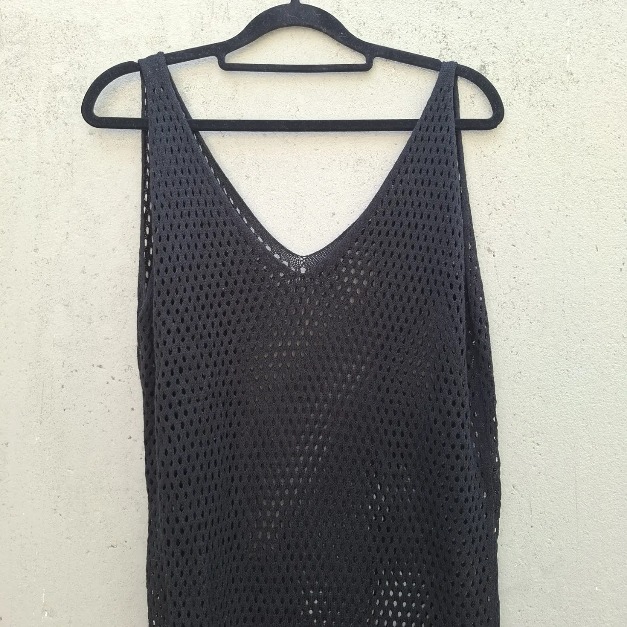 Vestido negro tejido al crochet, ideal para usar sobre la bikini en la playa o piscina. Su diseño calado le da un toque súper chic y fresco. Perfecto para un look relajado y a la moda.