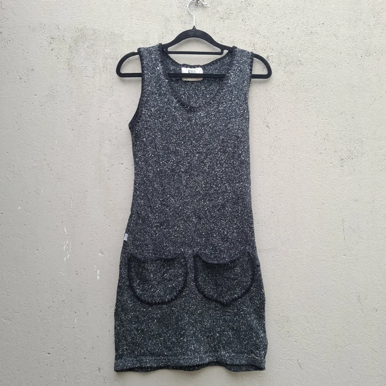 Vestido tejido sin mangas, con cuello en V y dos bolsillos grandes en la parte delantera. Ideal para un look casual y cómodo.