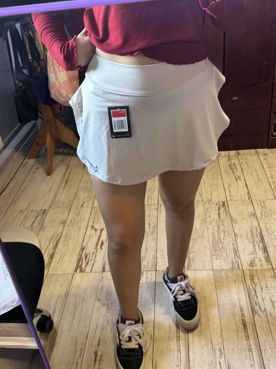 Pollera blanca con detalle de volados en el borde inferior. Tiene un logo pequeño en la parte inferior izquierda.