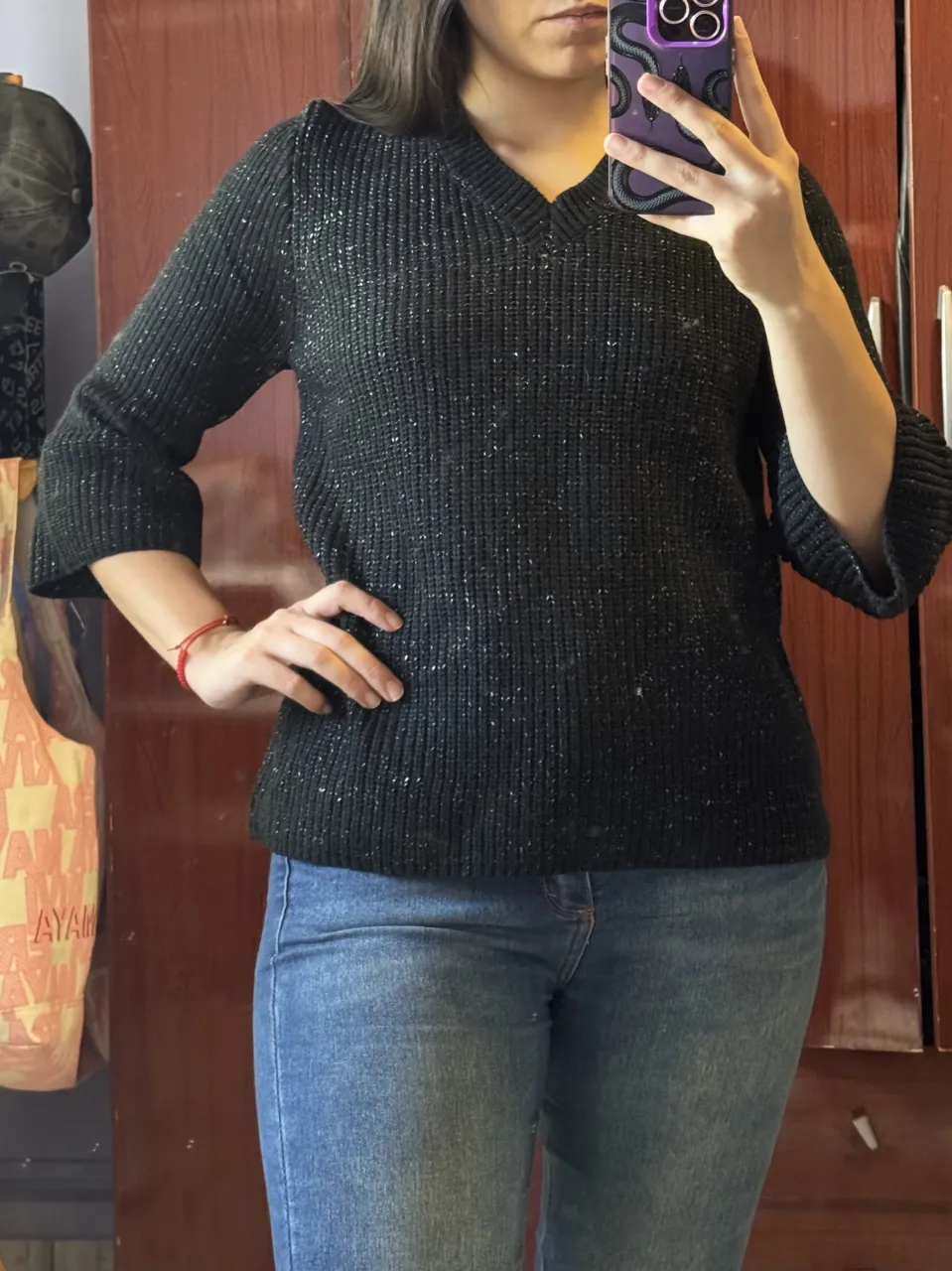 Sweater negro con hilos plateados. Posee escote en V y mangas 3/4 con detalle de volado.