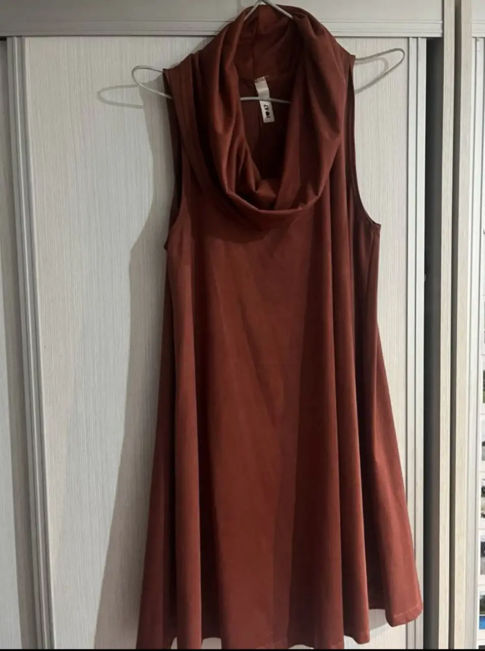 Vestido midi de mujer, color marrón, con cuello alto y corte amplio. Ideal para un look casual y cómodo.