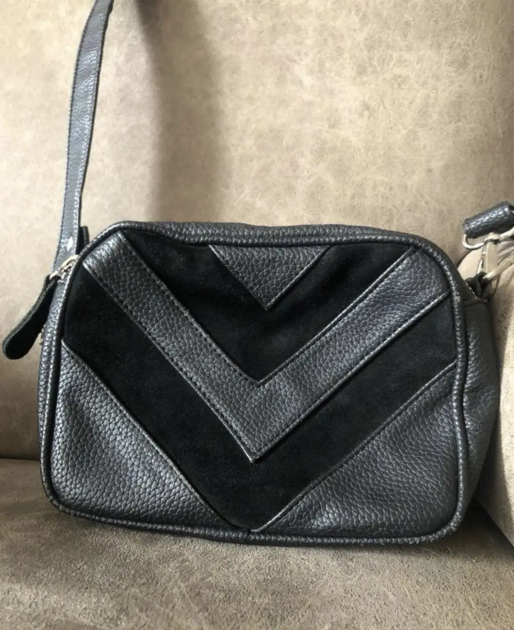 Bandolera negra con diseño en V de gamuza en el frente. dos cierres y un bolsillo interior con cierre. correa desmontable y regulable. ver detalle en 2da foto. 