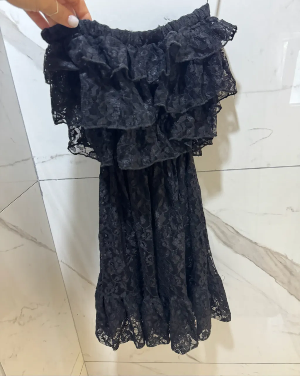 Vestido negro de encaje con volados en el busto y en el ruedo. Breteles finos.