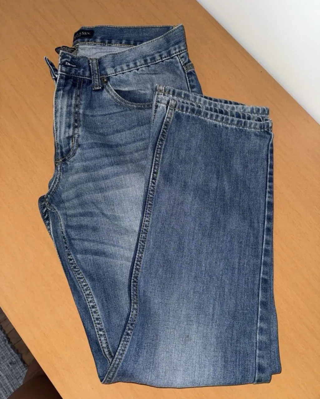 Jeans de corte recto, tiro medio, color azul clásico con detalles de desgaste. Perfectos para un look casual y moderno.