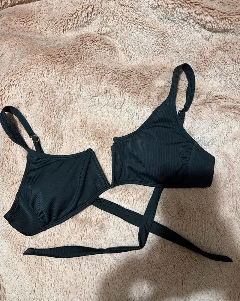 Top de bikini negro con tiras cruzadas y diseño moderno. Ideal para lucir espectacular en la playa o la piscina. Su estilo único te hará destacar.