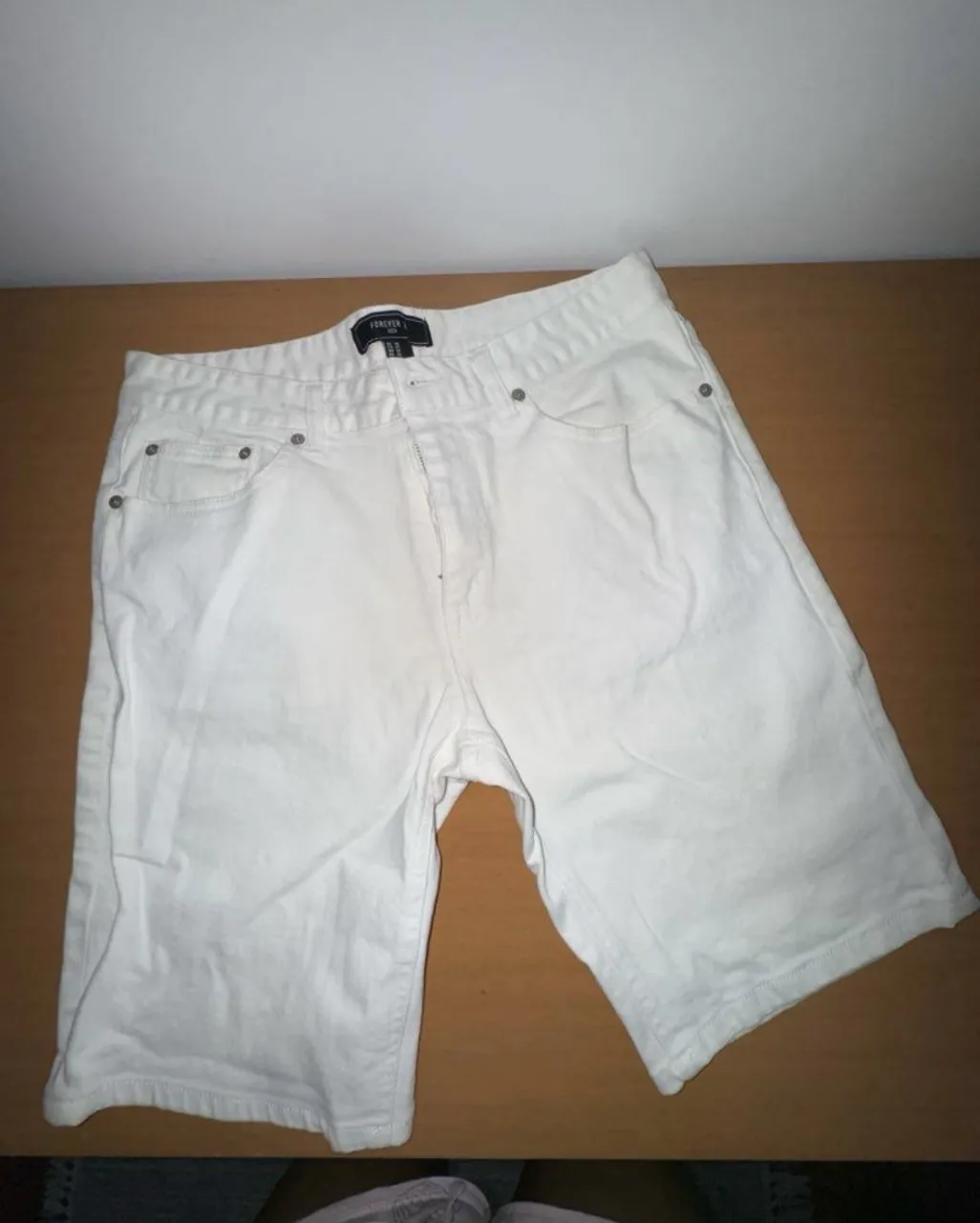 Shorts de jean blancos, tiro medio, estilo bermuda. Perfectos para un look casual de verano o para usar en la playa.