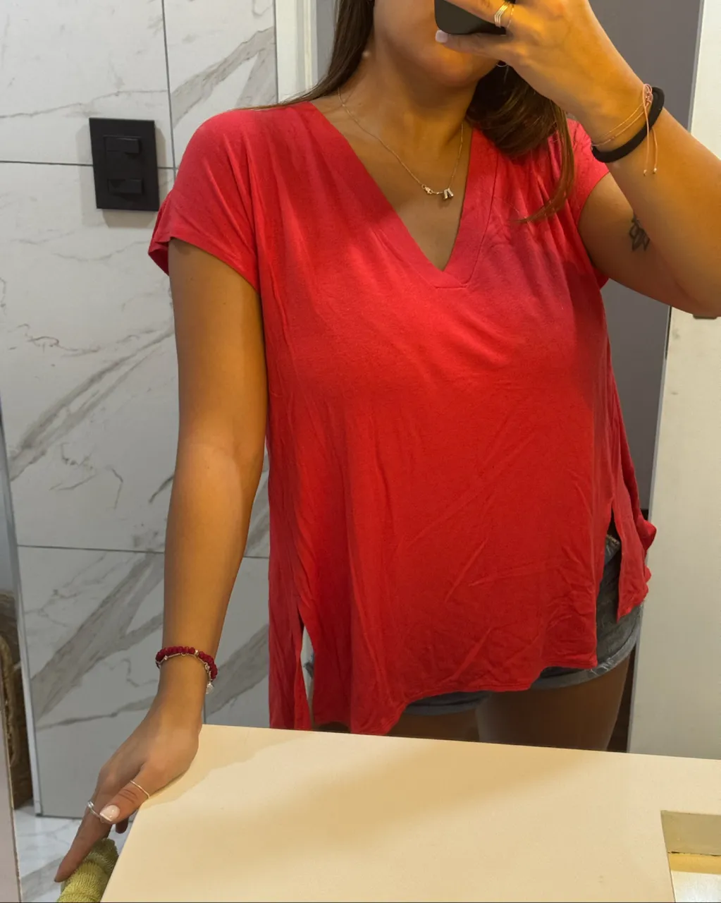 Remera roja de manga corta con escote en V y tajos laterales. Espalda cruzada.