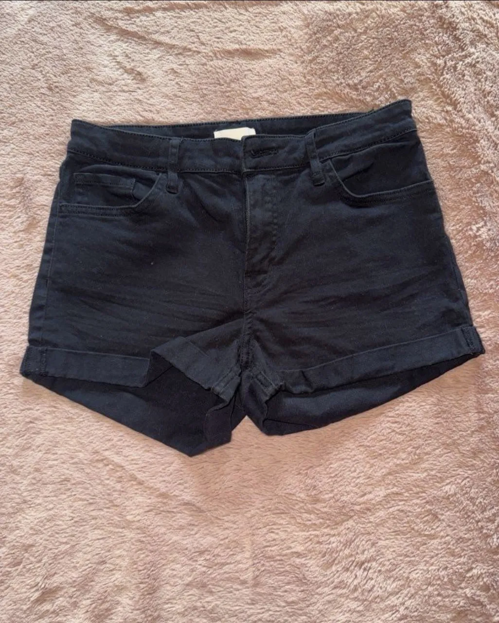 Shorts de jean negros tiro alto, con dobladillo en las botamangas. Perfectos para un look casual y canchero.