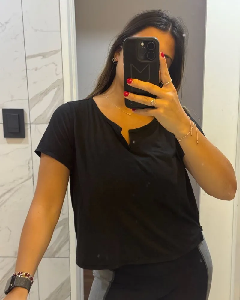 Remera negra de manga corta, con cuello escotado y detalle de botones. Ideal para entrenamientos o uso casual. Marca Calvin Klein.