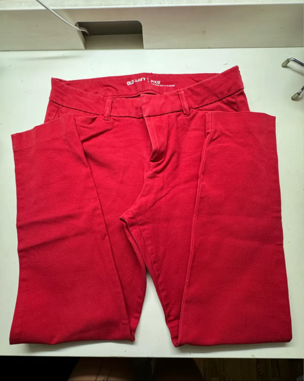 Pantalón rojo de vestir, tiro medio, con bolsillos delanteros y traseros. Marca Old Navy.