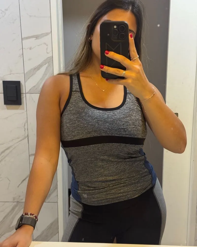 Musculosa deportiva gris con detalles en negro y azul. Ideal para entrenar o para un look casual y cómodo.