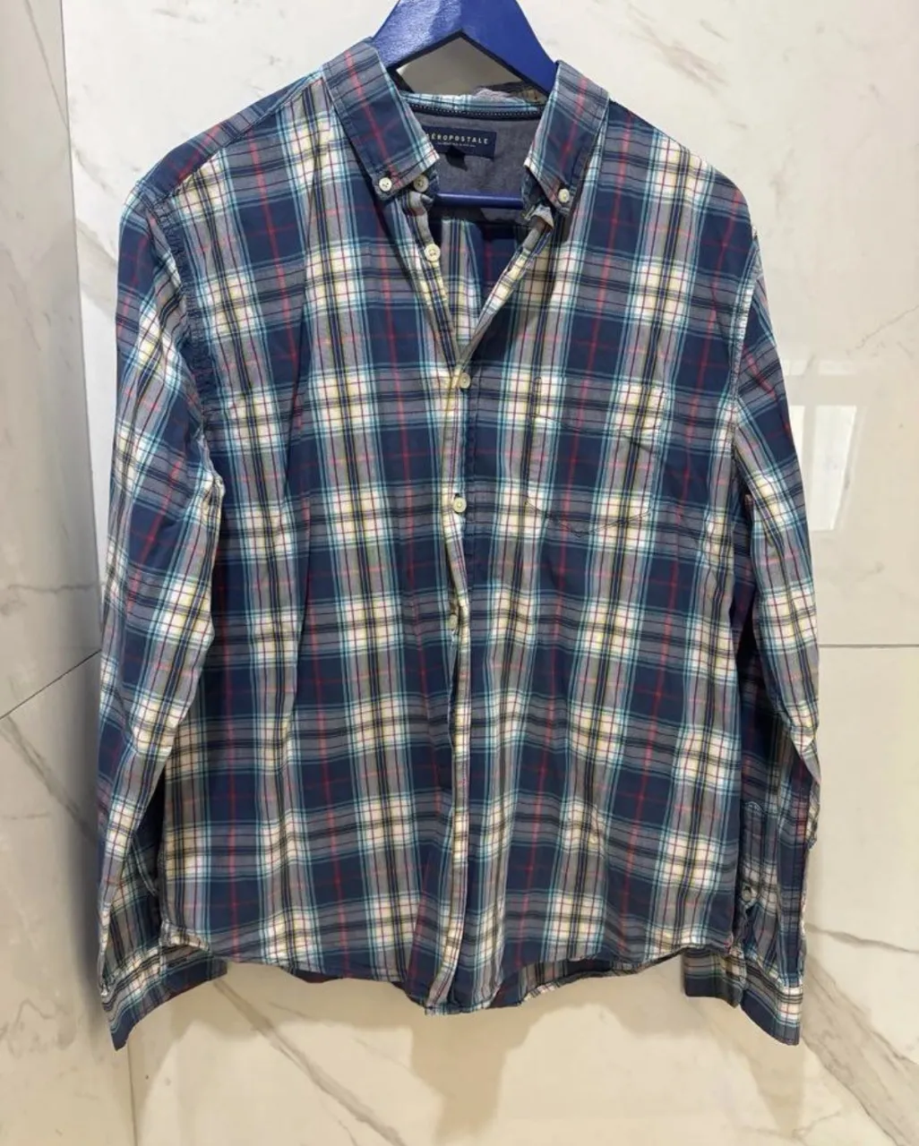 Camisa de leñador Aeropostale a cuadros en tonos azules, blancos, rojos y amarillos. Ideal para un look casual y cómodo.