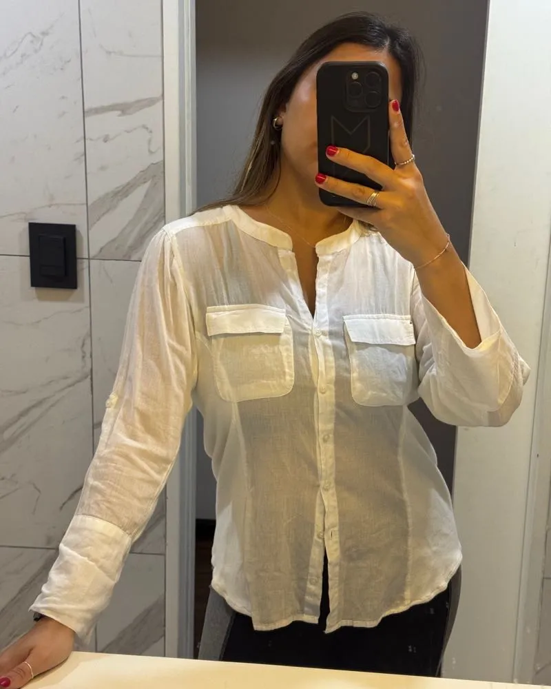 Camisa blanca de manga larga con dos bolsillos en el frente. Ideal para un look casual o de trabajo.