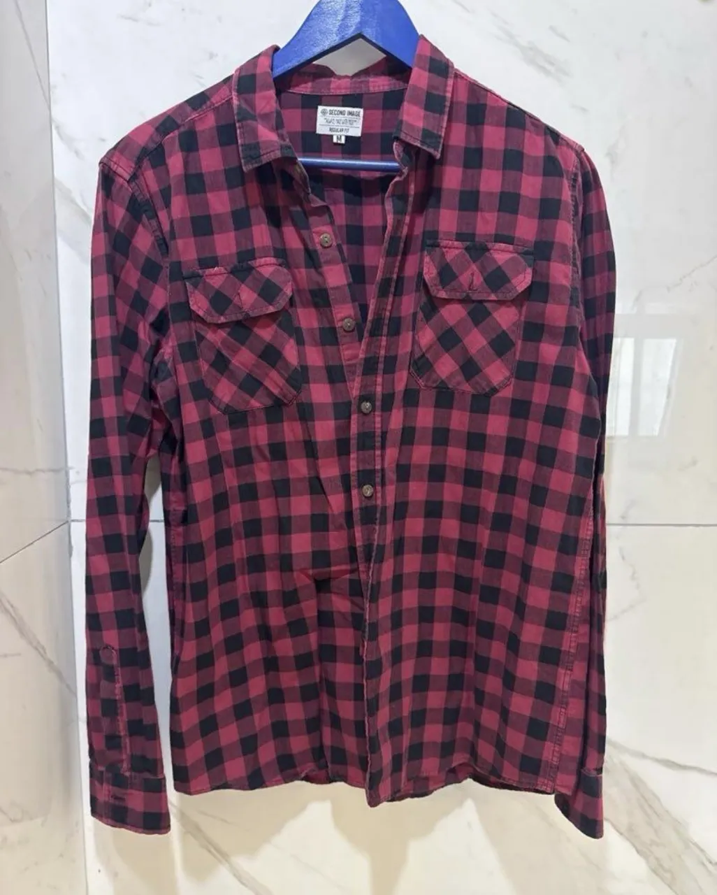 Camisa de leñador a cuadros rojos y negros, ideal para un look casual y relajado. Perfecta para combinar con jeans o pantalones cargo.