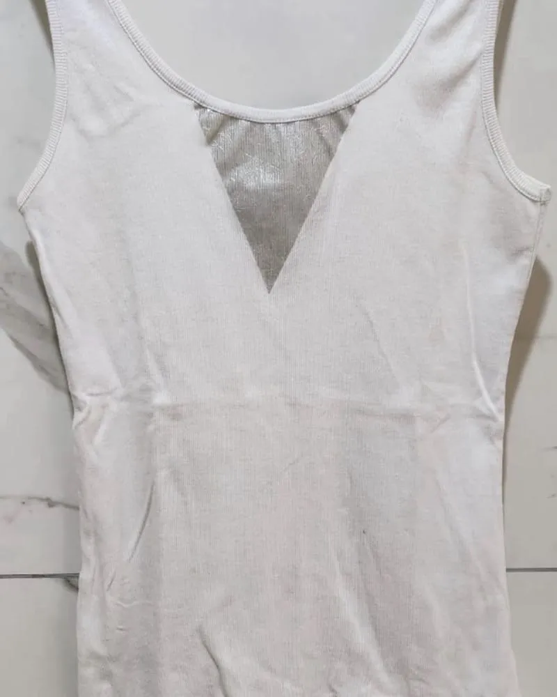 Musculosa blanca con detalle plateado en forma de V en el escote.