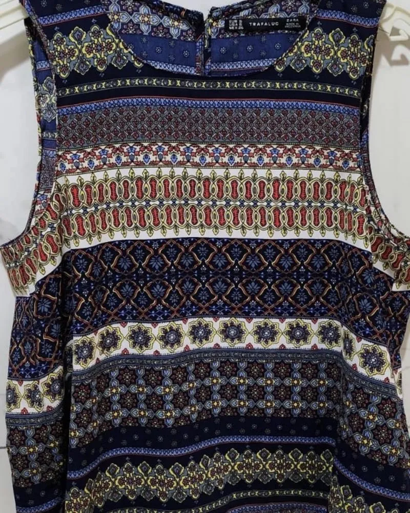 Musculosa estampada con motivos geométricos y florales en tonos azules, rojos, amarillos y blancos.