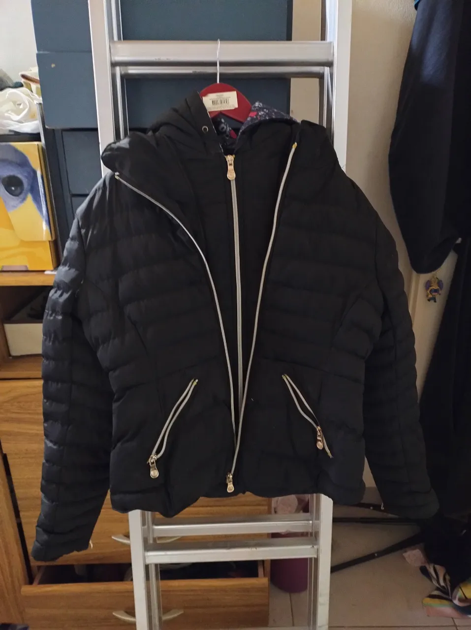 Campera negra acolchada con capucha y forro estampado floral. Ideal para días frescos y casuales. doble cierre. detalle en la axila hay que coserla