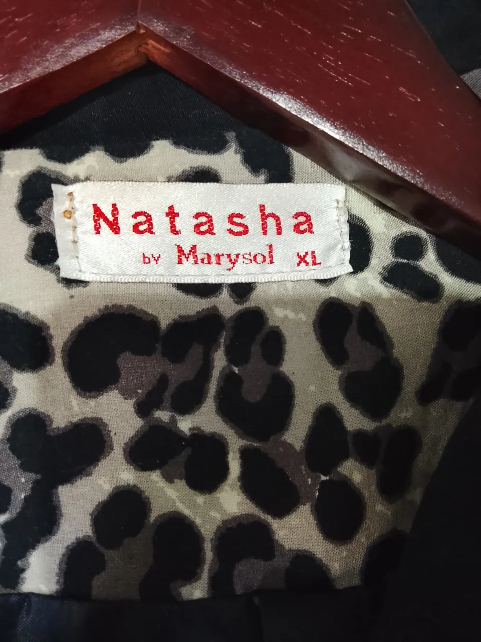 Blazer negro con forro estampado de leopardo. Los puños de las mangas están doblados y muestran el mismo estampado.